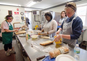 Volunteers work to prepare lunch in the kitchen at the Leominster Spanish American Center soup kitchen on Wednesday afternoon. SENTINEL & ENTERPRISE / Ashley Green
