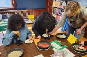 Two children work on a project with their teacher.